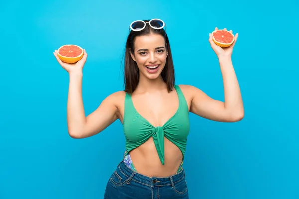 Junge Frau im Badeanzug in den Sommerferien mit Grapefruit — Stockfoto