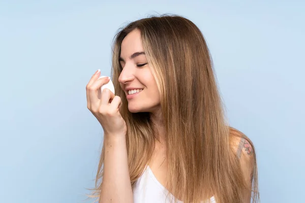 Mujer Joven Sobre Fondo Azul Aislado Con Crema Hidratante —  Fotos de Stock