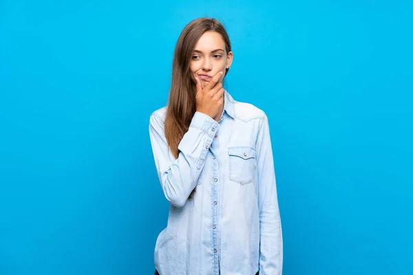 Ung Kvinna Över Isolerad Blå Bakgrund Tänkande — Stockfoto