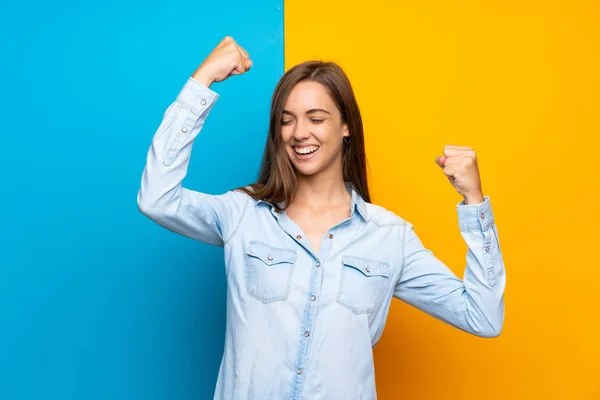 Bir Zafer Kutluyor Renkli Arka Plan Üzerinde Genç Kadın — Stok fotoğraf