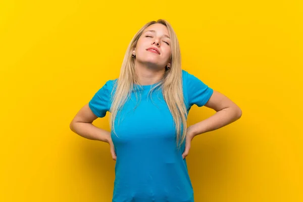Junge Blonde Frau Mit Gelbem Hintergrund Leidet Unter Rückenschmerzen Weil — Stockfoto