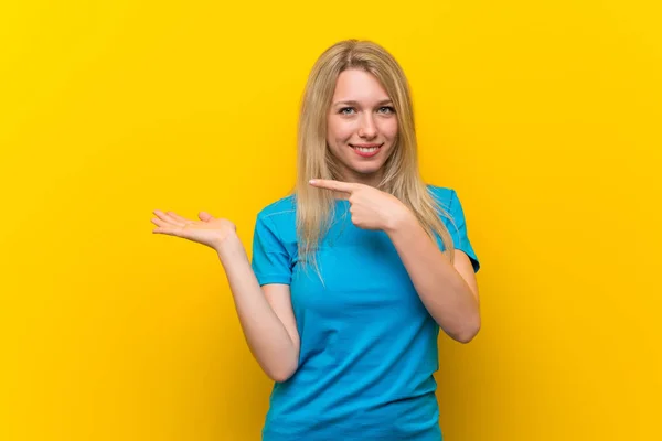 Jonge Blonde Vrouw Geïsoleerde Gele Achtergrond Houden Copyspace Imaginaire Palm — Stockfoto