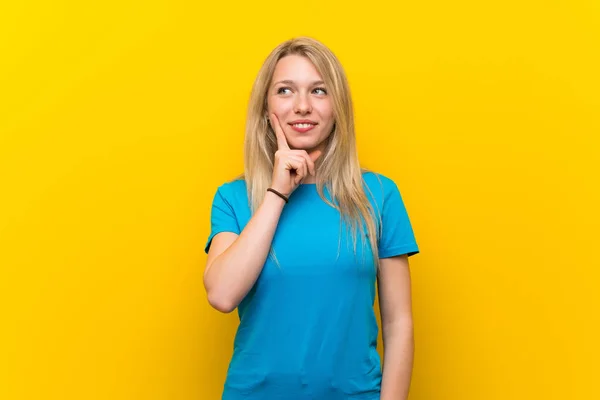 Jonge Blonde Vrouw Geïsoleerde Gele Achtergrond Denken Een Idee Tijdens — Stockfoto