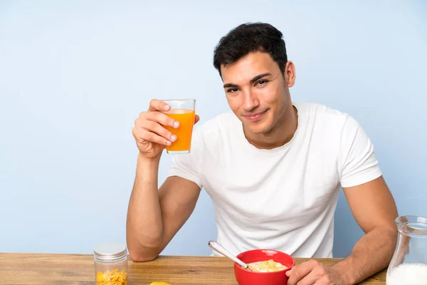 Handsome man holding an orange juice