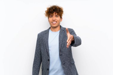 Iyi bir anlaşma kapanış için el sıkışma izole beyaz duvar üzerinde Moda afro-amerikan adam