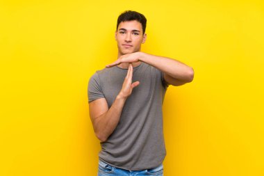Izole sarı duvar üzerinde yakışıklı adam jest zaman dışarı yapma
