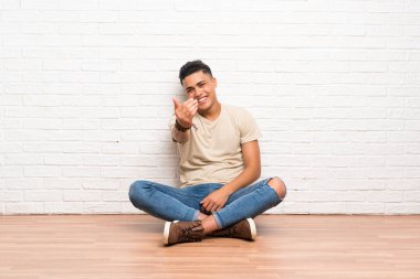 Genç adam gelmeye davet katta oturan