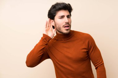 Izole duvar üzerinde yakışıklı bir şey dinlerken