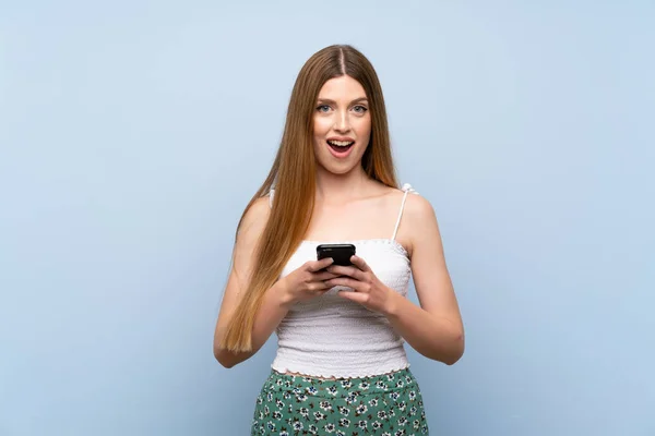 Mujer Joven Sobre Fondo Azul Aislado Sorprendido Enviando Mensaje —  Fotos de Stock