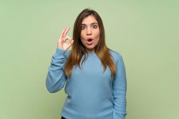 Chica Joven Sobre Pared Verde Sorprendida Mostrando Signo — Foto de Stock