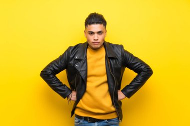Izole sarı arka plan kızgın üzerinde genç adam