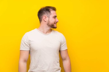 Sarı arka planda yakışıklı adam tarafına bakıyor