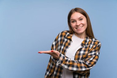 Mavi duvarın üzerinde genç kadın gelmeye davet için ellerini yana uzatıyor