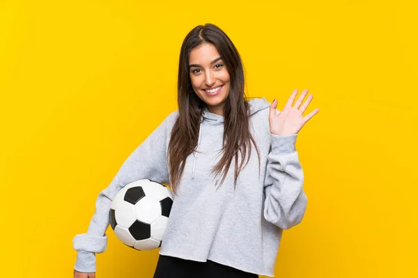 Giovane Giocatore Calcio Donna Isolato Sfondo Giallo Saluto Con Mano — Foto Stock