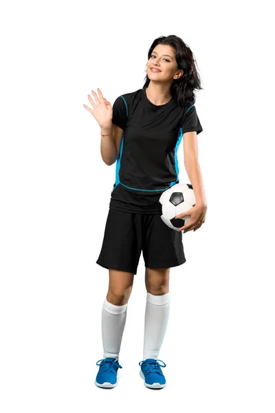 孤立した白い背景の上に幸せな表情で手で敬礼する若いサッカー選手の女性のフルレングスショット — ストック写真