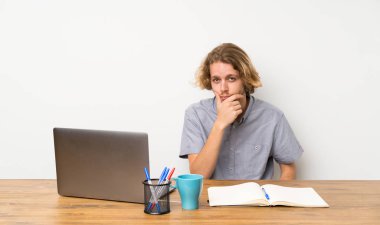 Bir dizüstü bilgisayar düşünme ile Sarışın adam