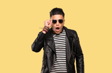 Gözlüklü genç adam ve izole arka plan üzerinde şaşırttı