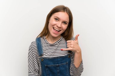 Beyaz duvar üzerinde dungarees genç kadın telefon jestyapma