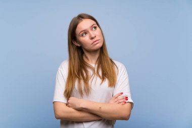 Genç kadın üzerinde mavi duvar görünümlü yukarı ile ciddi yüz