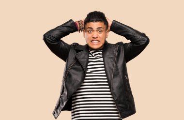 Genç adam sinirli ve izole arka plan üzerinde baş ellerini alır