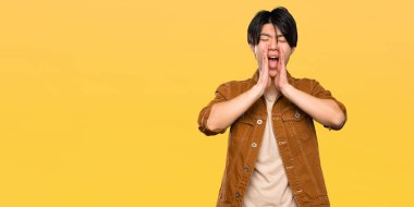 Kahverengi ceketli Asyalı adam bağırıyor ve izole sarı arka plan üzerinde bir şey ilan