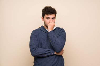 İzole duvar üzerinde kıvırcık saçlı adam şüpheleri olan