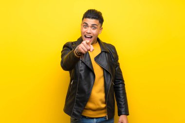 Izole sarı arka plan üzerinde genç adam şaşırttı ve ön işaret