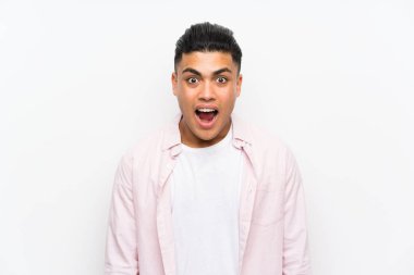 Sürpriz yüz ifadesi ile izole beyaz duvar üzerinde genç adam
