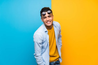 Güneş gözlüğü ile izole renkli arka plan üzerinde Genç adam