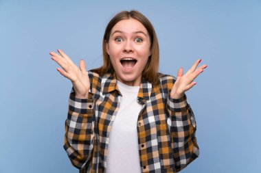 Sürpriz yüz ifadesi ile mavi duvar üzerinde genç kadın