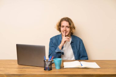 Sessizlik jesti yapan bir dizüstü bilgisayar ile Sarışın adam