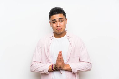 Izole beyaz duvar yalvaran üzerinde genç adam