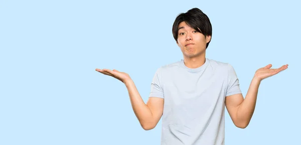 Asian Man Blue Shirt Making Doubts Gesture Isolated Blue Background — Stock Photo, Image