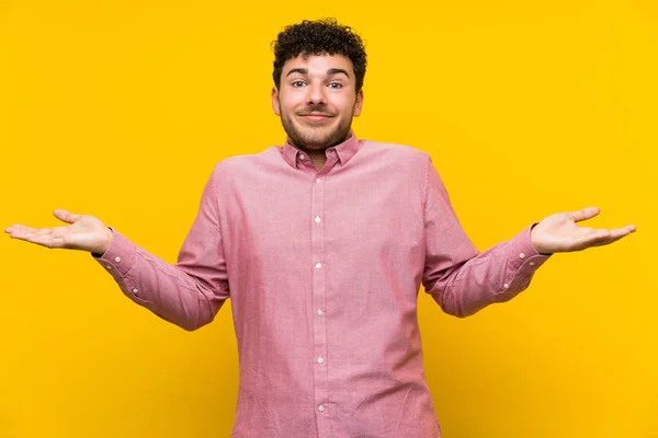 Man Curly Hair Isolated Yellow Wall Having Doubts Confuse Face — Stock Photo, Image