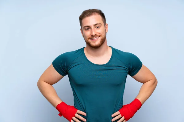 금발의 스포츠 남자 위에 푸른 벽 에 권투 붕대 — 스톡 사진