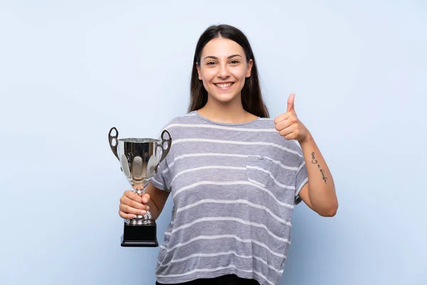 Jovem Morena Sobre Fundo Azul Isolado Segurando Troféu — Fotografia de Stock