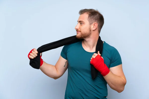 Blonde sport man over blue wall