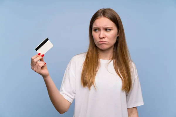 Mujer Joven Sobre Pared Azul Tomando Una Tarjeta Crédito Sin — Foto de Stock