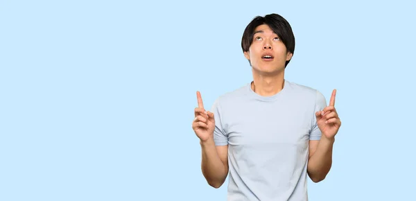 Asian Man Blue Shirt Surprised Pointing Isolated Blue Background — Stock Photo, Image