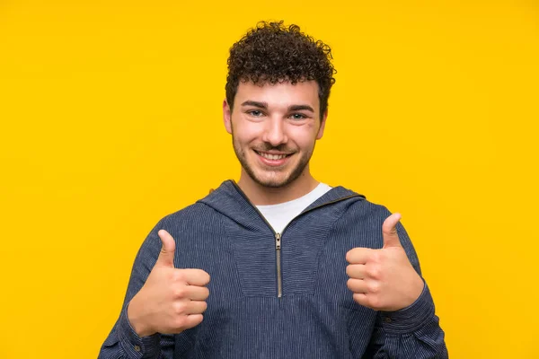 Young Man Isolated Yellow Wall Giving Thumbs Gesture — Stock Photo, Image
