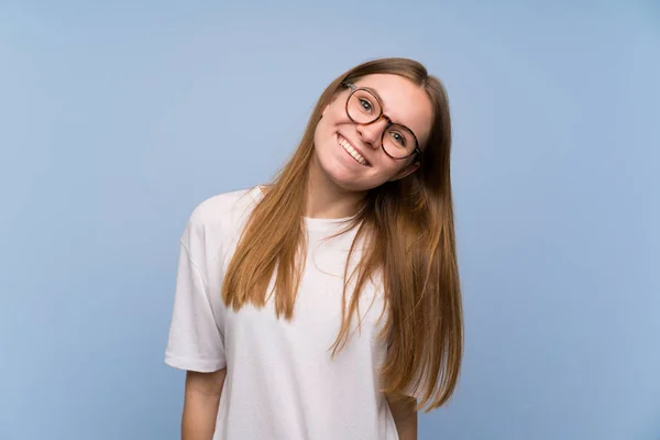 Mavi Duvar Ile Gözlük Gülümseyen Genç Kadın — Stok fotoğraf