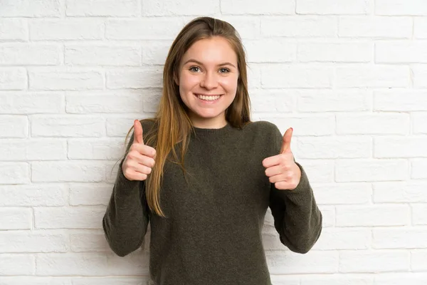 Jonge Vrouw Witte Bakstenen Muur Geven Een Duim Omhoog Gebaar — Stockfoto