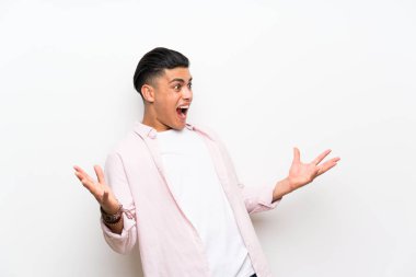 Sürpriz yüz ifadesi ile izole beyaz duvar üzerinde genç adam