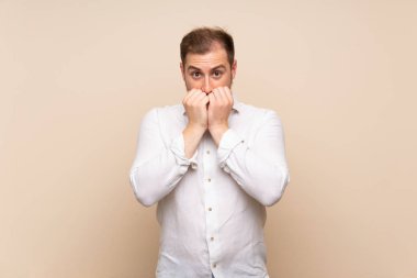 Izole arka plan sinir üzerinde Sarışın adam ve ağıza ellerini koyarak korkmuş