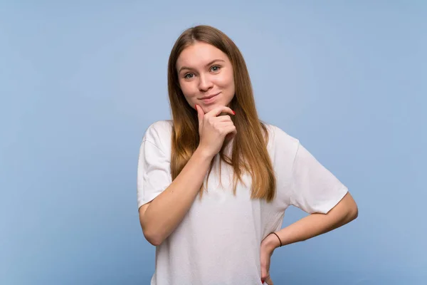 Junge Frau Über Blauer Wand Lächelt Und Blickt Mit Selbstbewusstem — Stockfoto