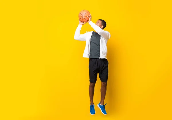 Αφροαμερικανός Παίχτης Του Μπάσκετ Πάνω Από Απομονωμένο Κίτρινο Φόντο — Φωτογραφία Αρχείου