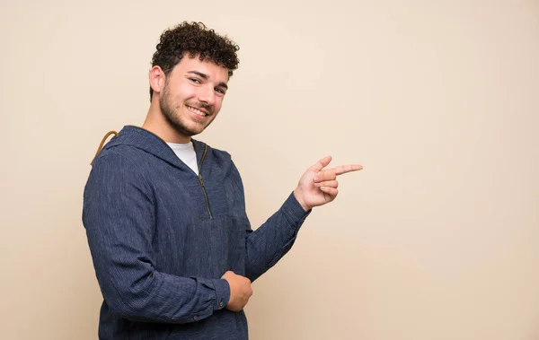 Uomo Con Capelli Ricci Sopra Parete Isolata Che Punta Dito — Foto Stock