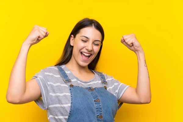 Mujer Joven Las Mazmorras Sobre Fondo Amarillo Aislado Celebrando Una —  Fotos de Stock