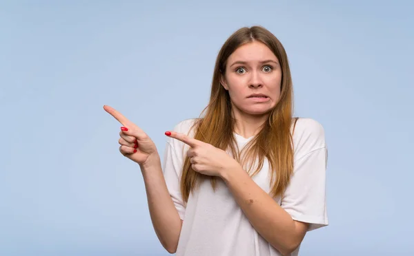 Jonge Vrouw Blauwe Muur Bang Wijst Naar Kant — Stockfoto