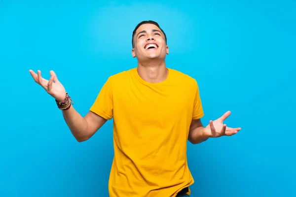 Mladý Muž Žlutou Košilí Přes Izolované Modré Pozadí Hodně Usmívá — Stock fotografie